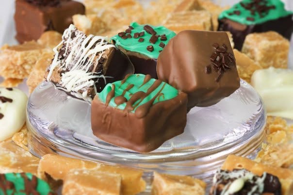An assortment of handmade chocolate-covered candies arranged on a glass stand