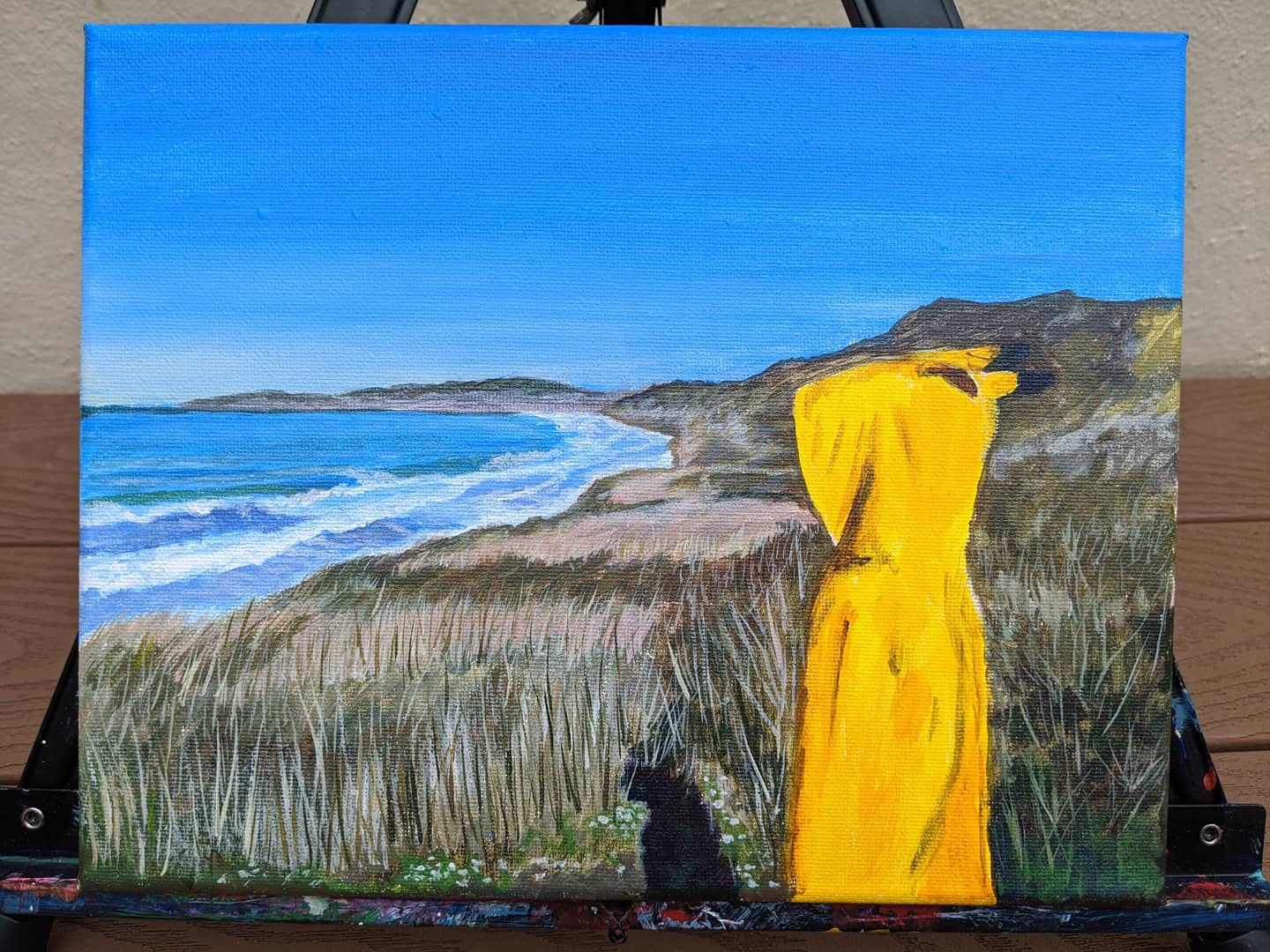 A painting of the artist’s son in a yellow Pikachu hoodie overlooking the beach at Mussel Rock