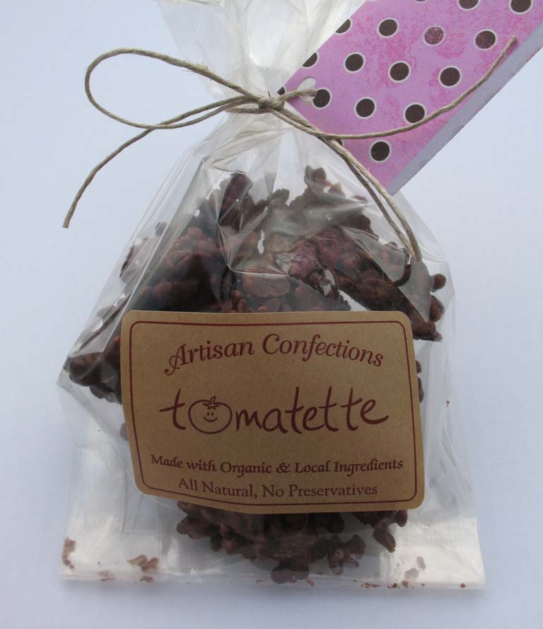 A clear bag of chocolate treats tied with twine and labeled Tomatette Artisan Confections